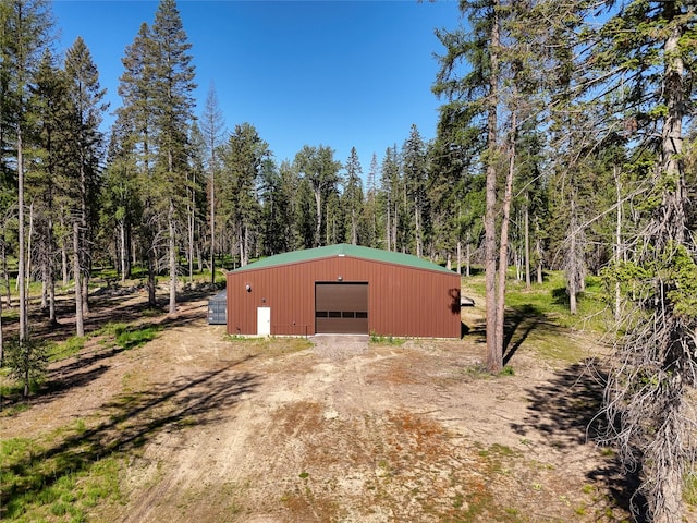 190 Black Bear Ln, Bigfork, MT 59911 - view of outdoor structure featuring dirt driveway and a view of trees