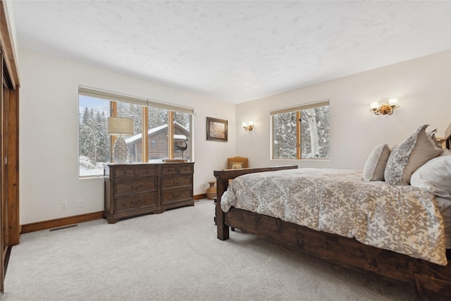 carpeted bedroom featuring multiple windows