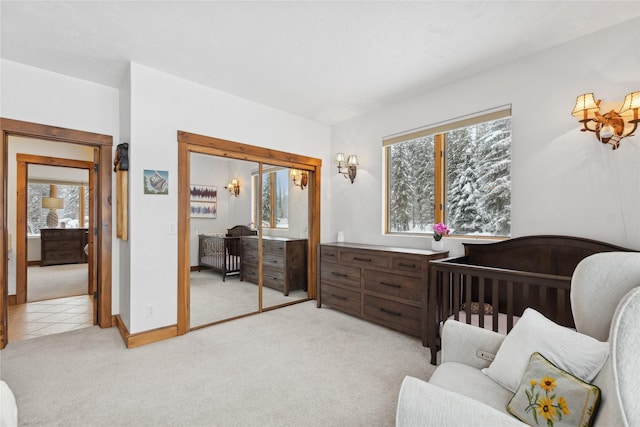 carpeted bedroom featuring a closet and a nursery area