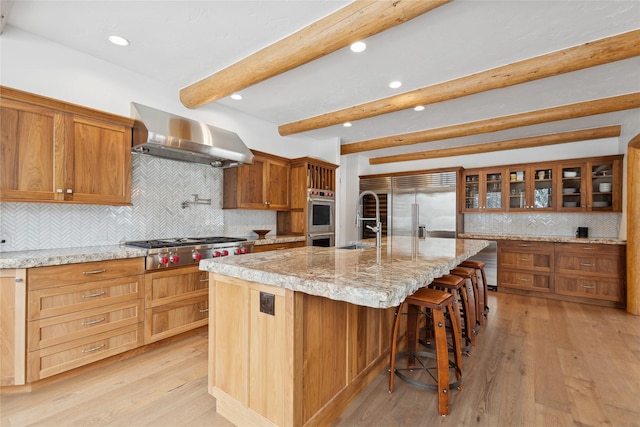 190 Black Bear Ln, Bigfork, MT 59911 - kitchen featuring wall chimney exhaust hood, stainless steel appliances, beam ceiling, recessed lighting, and tasteful backsplash