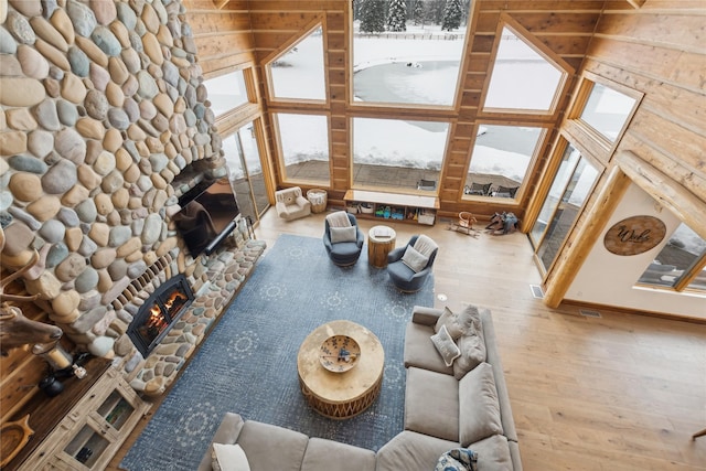 living room featuring hardwood / wood-style flooring, a fireplace, and a high ceiling