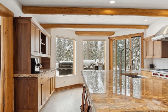 190 Black Bear Ln, Bigfork, MT 59911 - kitchen featuring recessed lighting, light stone counters, beam ceiling, light wood finished floors, and tasteful backsplash