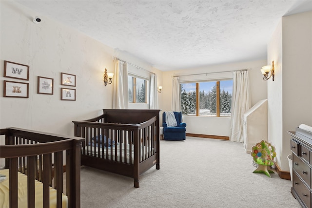 bedroom with a textured ceiling, light colored carpet, and a crib