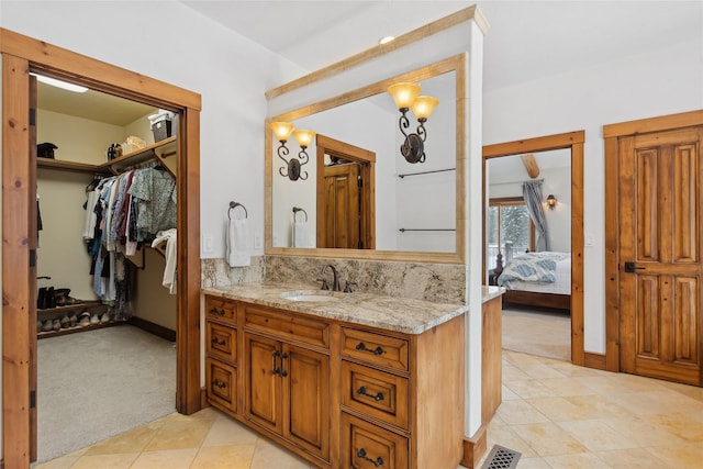 190 Black Bear Ln, Bigfork, MT 59911 - ensuite bathroom with vanity, a walk in closet, tile patterned floors, and baseboards