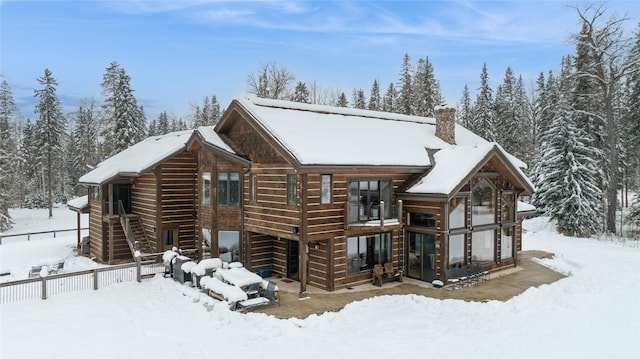 view of snow covered back of property