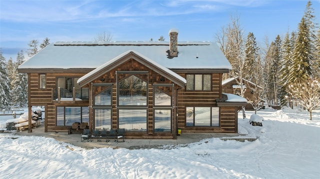 view of snow covered back of property