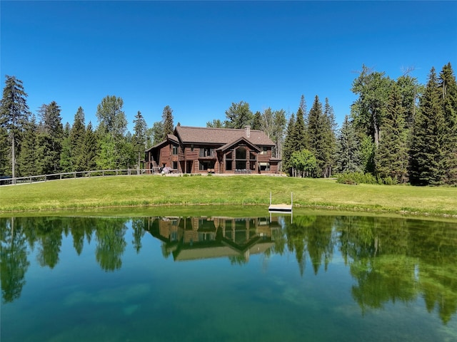 190 Black Bear Ln, Bigfork, MT 59911 - back of house with a water view, a chimney, and a wooded view