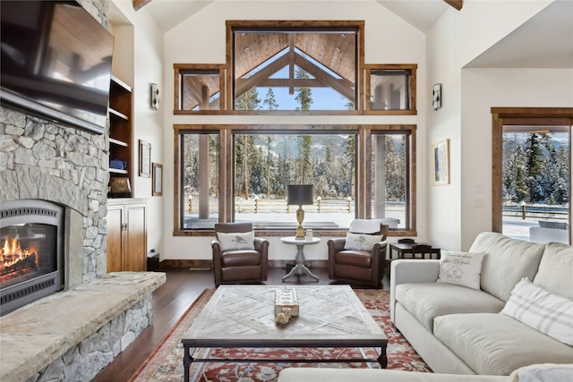 living room featuring lofted ceiling, built in shelves, a fireplace, and dark hardwood / wood-style flooring