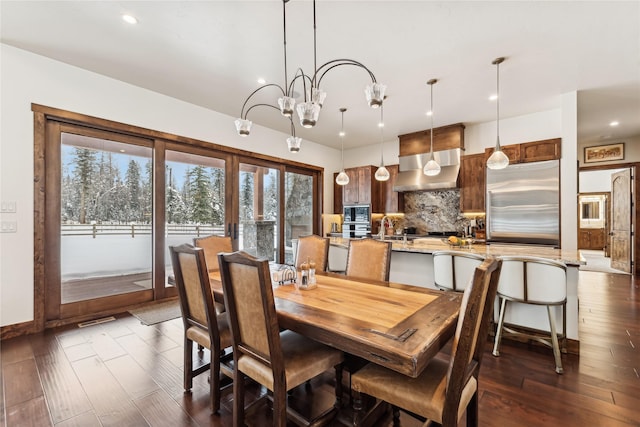 dining room with dark hardwood / wood-style floors and an inviting chandelier