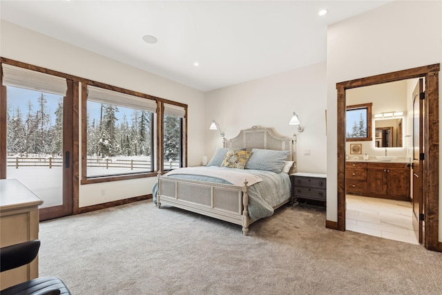 bedroom with ensuite bath, light colored carpet, and access to exterior