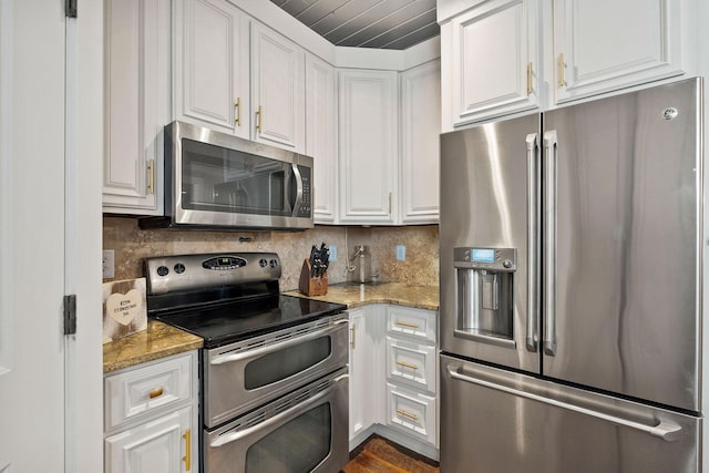 kitchen with white cabinetry, stainless steel appliances, backsplash, and light stone counters