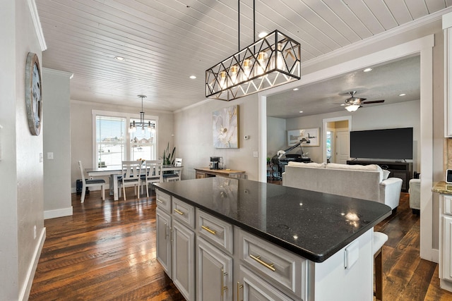 kitchen with dark wood-type flooring, decorative light fixtures, wood ceiling, crown molding, and a center island