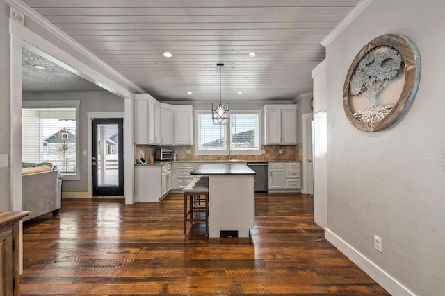 kitchen with white cabinetry, a kitchen island, a kitchen breakfast bar, and decorative light fixtures