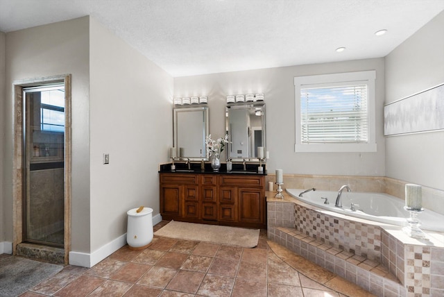 bathroom featuring vanity, independent shower and bath, a textured ceiling, and a wealth of natural light