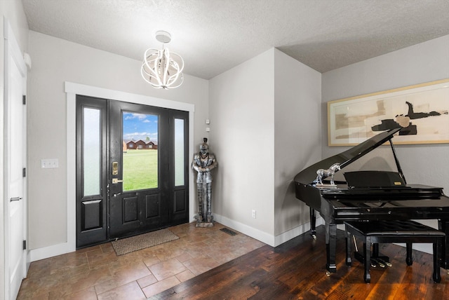 entrance foyer featuring a textured ceiling and an inviting chandelier