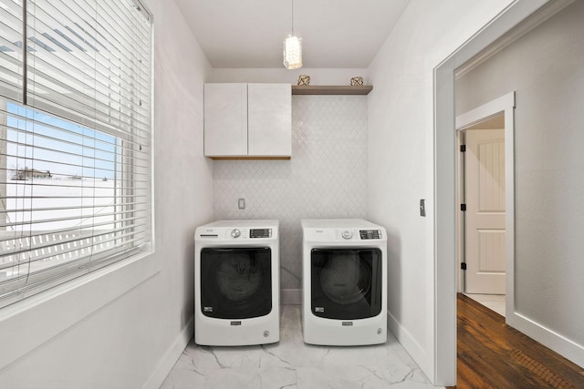 laundry room featuring washing machine and clothes dryer and cabinets