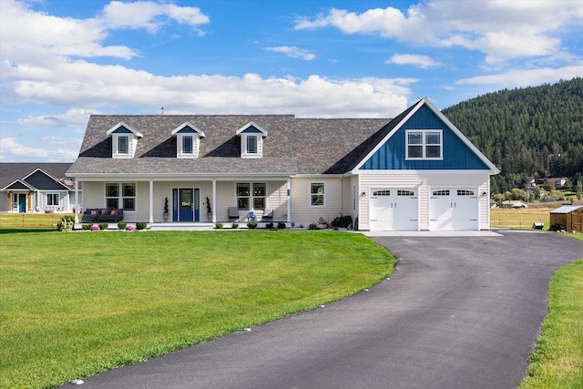 view of front of home featuring a front yard, a garage, and a porch