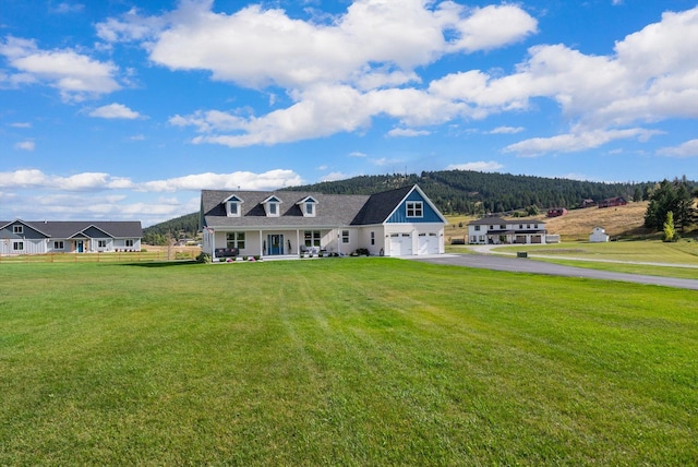 view of front facade with a garage, a mountain view, and a front lawn