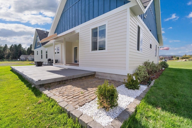 back of property featuring a patio area and a lawn