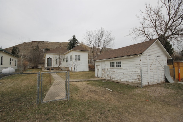 exterior space with a gate, a yard, an outdoor structure, a storage unit, and fence private yard