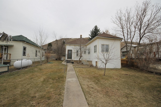 view of front facade featuring fence, a front lawn, and entry steps