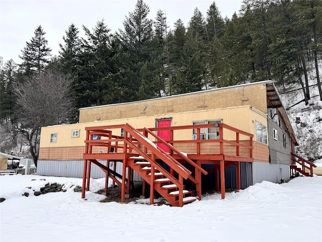 snow covered property with a wooden deck