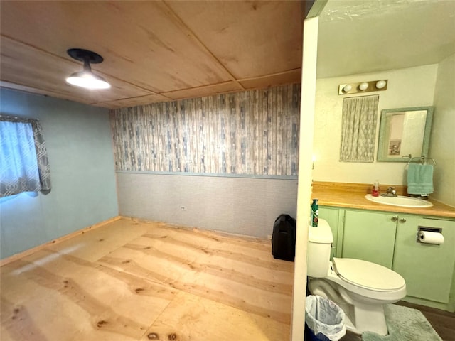 bathroom with wooden walls, vanity, and toilet