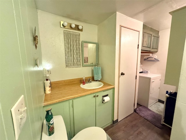 bathroom featuring toilet, washer / clothes dryer, vanity, and hardwood / wood-style flooring