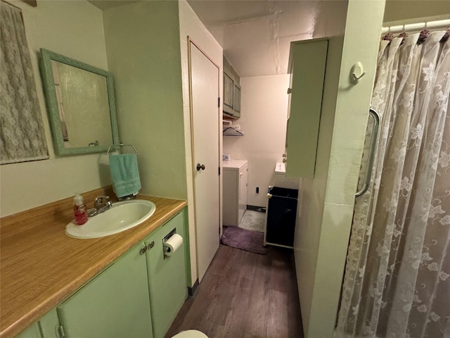 bathroom with vanity, hardwood / wood-style floors, and washing machine and clothes dryer