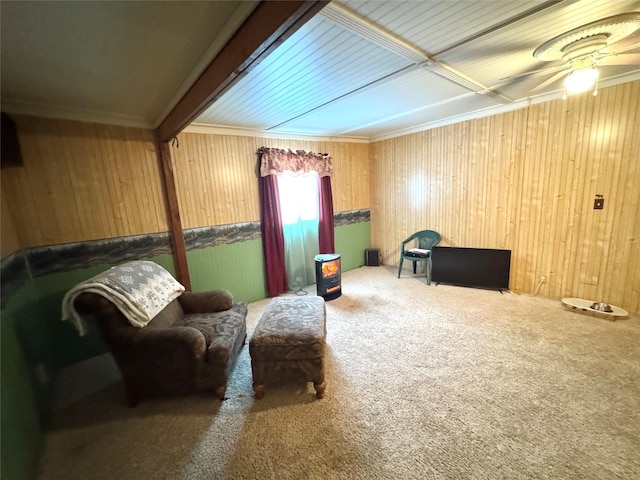 living area featuring ceiling fan, wooden walls, and carpet flooring