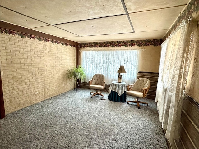 unfurnished room with brick wall and carpet floors