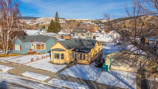 snowy aerial view featuring a residential view and a mountain view