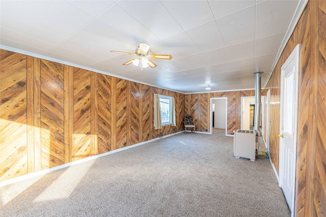 basement with carpet floors, ornamental molding, and ceiling fan