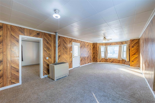 unfurnished room featuring ceiling fan, carpet, heating unit, and ornamental molding