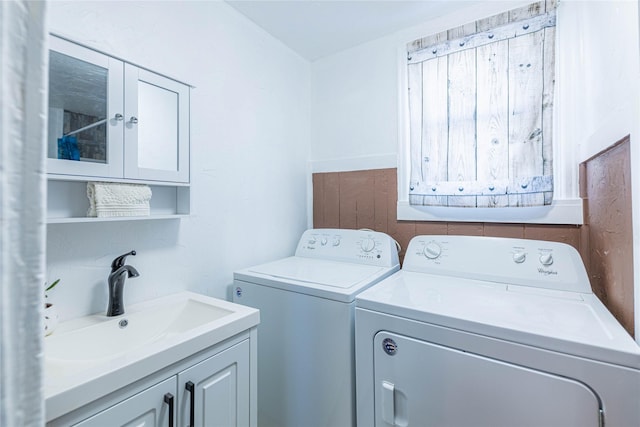 laundry area with washer and dryer, sink, and cabinets