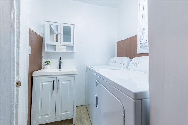 laundry area featuring washer and dryer, hardwood / wood-style floors, and sink