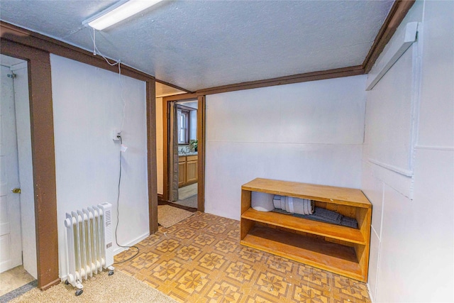 hallway with radiator heating unit and ornamental molding