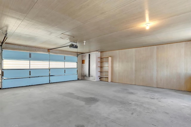 garage featuring a garage door opener and wood walls