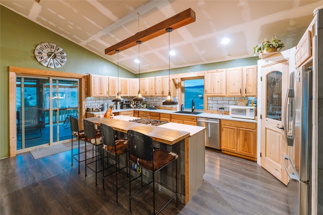 kitchen with dark wood-style floors, a breakfast bar, a center island, decorative light fixtures, and stainless steel appliances