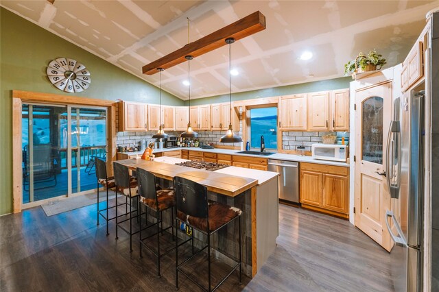 kitchen featuring decorative backsplash, vaulted ceiling, dark wood-style floors, and stainless steel appliances