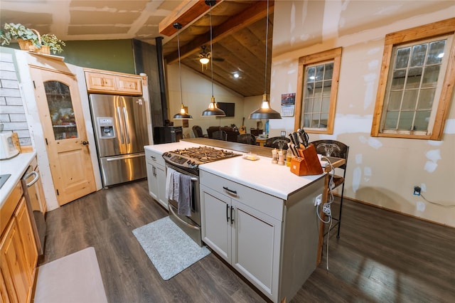 kitchen featuring lofted ceiling with beams, a kitchen island, appliances with stainless steel finishes, hanging light fixtures, and light countertops