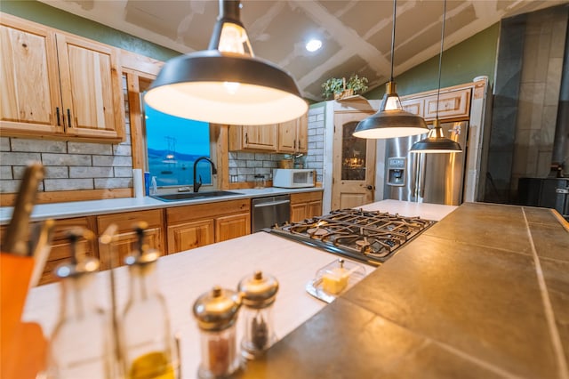 kitchen featuring a sink, white microwave, dishwasher, and hanging light fixtures