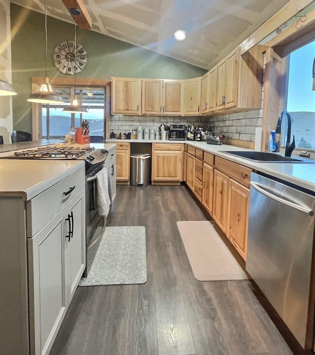 kitchen with lofted ceiling, light brown cabinets, light countertops, appliances with stainless steel finishes, and hanging light fixtures