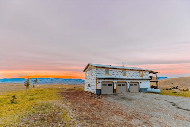 exterior space with a garage, a mountain view, and driveway