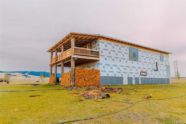 view of side of property with a lawn and a mountain view