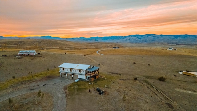 aerial view at dusk with a rural view and a mountain view