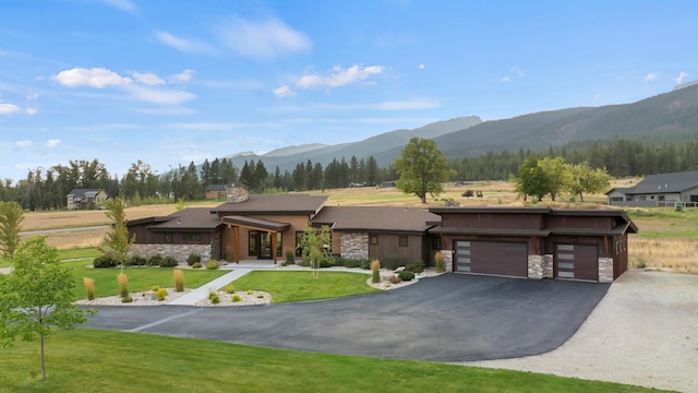 view of front facade with a front yard, a mountain view, and a garage