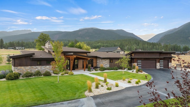 view of front of property with a front yard, a garage, and a mountain view