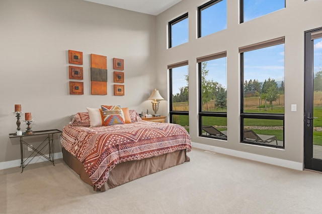 bedroom with light colored carpet and multiple windows