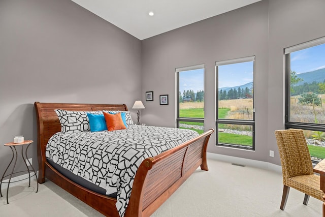 bedroom with light carpet and multiple windows